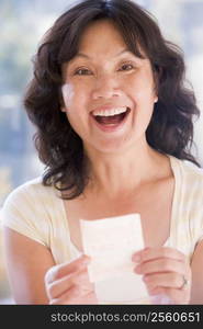 Woman with winning lottery ticket excited and smiling