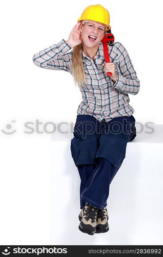 Woman with wrench struggling to hear