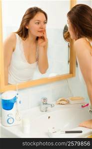Woman without makeup in bathroom.. Young girl woman without makeup in bathroom looking in mirror. Natural beauty. Purity.