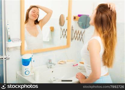 Woman without makeup relaxing in bathroom.. Young girl woman without makeup relaxing in bathroom looking in mirror. Natural beauty. Purity.