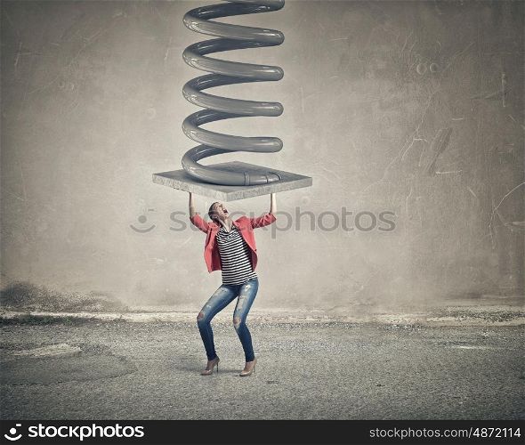 Woman withstand pressure. Young woman in red jacket resisting big metal spring