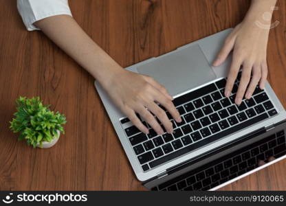 woman working and typing on the keyboard on table at home.Top view