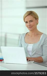Woman working at a white laptop computer