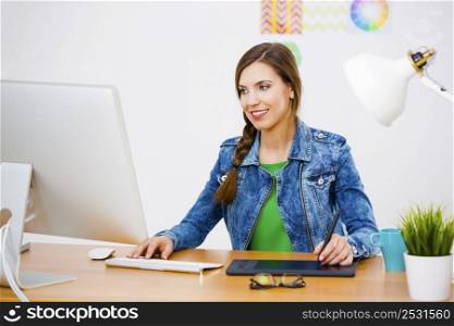 Woman working at desk In a creative office holding a cup