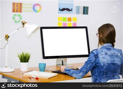 Woman working at desk In a creative office, using a computer