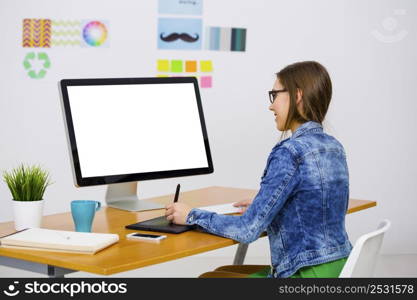 Woman working at desk In a creative office, using a computer