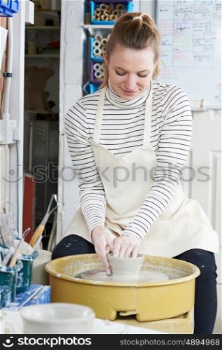 Woman Working At Pottery Wheel In Studio