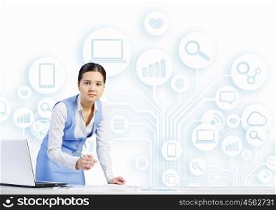 Woman working at table. Young businesswoman at desk with laptop and cloud computing concept on background