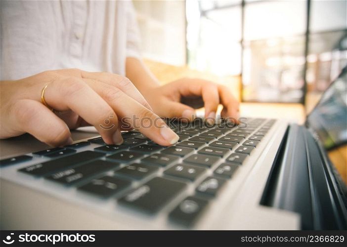 Woman working by using a laptop computerHands typing on keyboard. writing a blog. Working at home are in hand finger typewriter