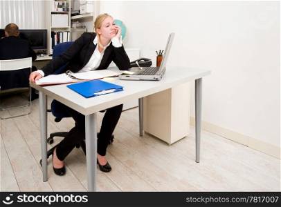 Woman, working in an office, staring blankly at a blind wall out of boredom