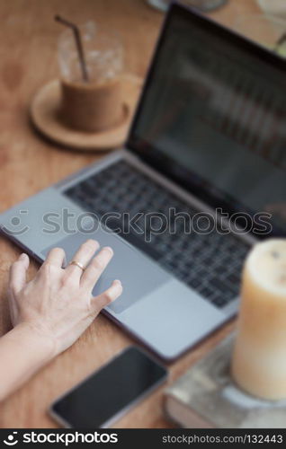 Woman working on computer in coffee shop, stock photo