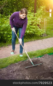 Woman working on garden bed at sunny day