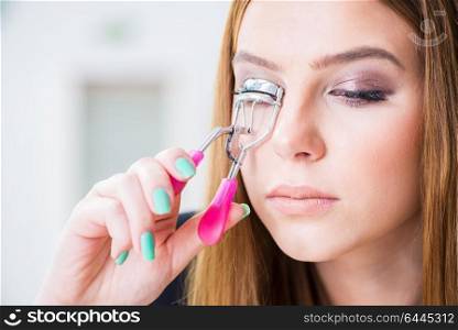 Woman working on her eyelashes in beauty concept