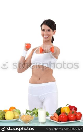 Woman working out in front of vegetables