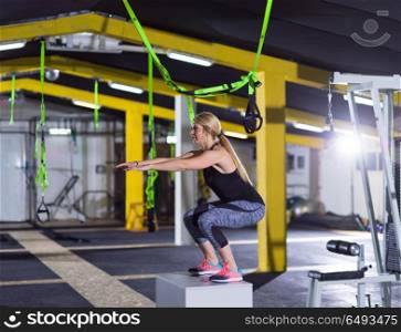 woman working out jumping on fit box. young athletic woman training jumping on fit box at crossfitness gym