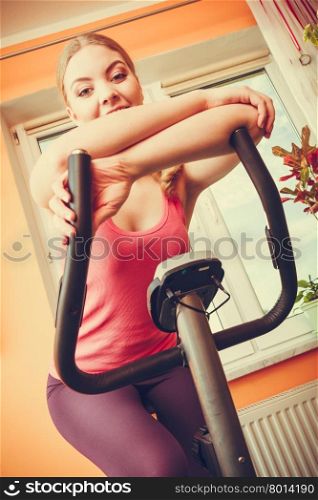 Woman working out on exercise bike. Fitness.. Active young woman working out on exercise bike stationary bicycle. Sporty girl training at home. Fitness and weight loss concept.