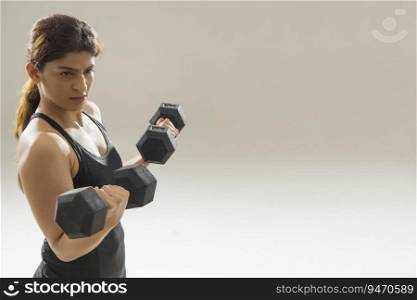 Woman working out with dumbbells in her hand. 
