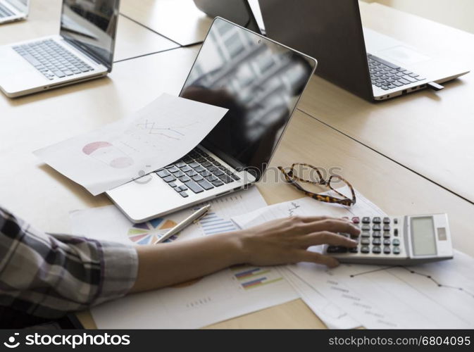 woman working with calculator, business document and laptop computer notebook