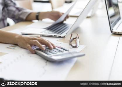 woman working with calculator, business document and laptop computer notebook
