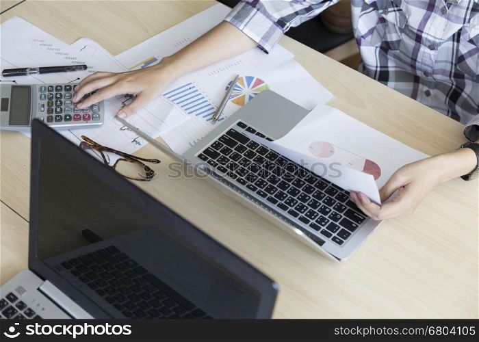 woman working with calculator, business document and laptop computer notebook