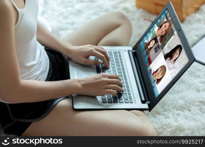 woman working with laptop and VDO Call Conference to meeting business team during quarantine coronavirus sitting on carpet at home,Video conference work from home concept