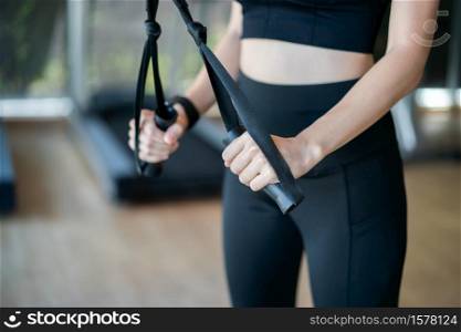 Woman workout triceps lifting weights in gym.
