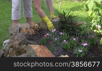 woman works on flower bed.