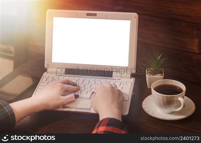 Woman works using laptop. Eco-friendly workspace mockup. Modern home office and a cup of coffee.. Woman works using laptop. Eco-friendly workspace mockup. Modern home office and cup of coffee.