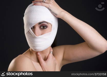 Woman Wrapped in White Gauze Holding Head Injury Needs Medical Treatment