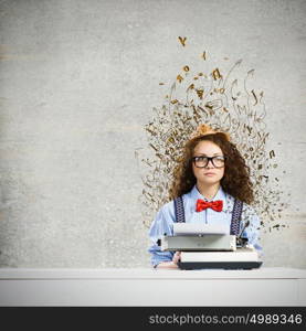 Woman writer. Young funny woman in glasses using typewriter