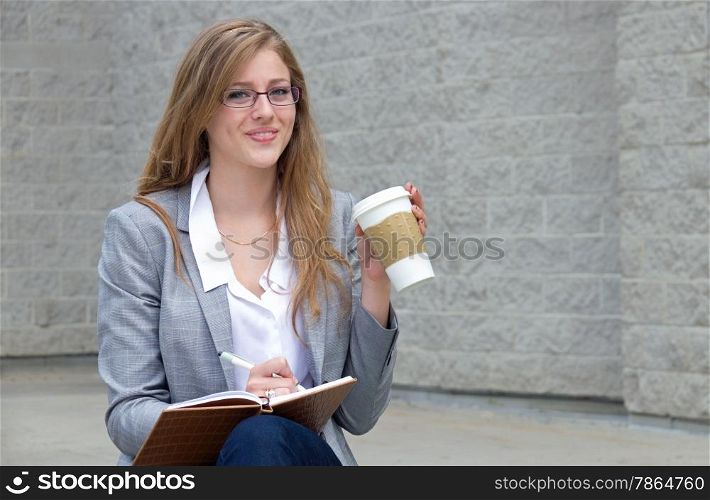 Woman writes in journal and drinks her coffee