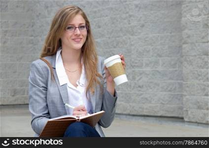 Woman writes in journal and drinks her coffee