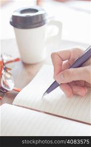 Woman writing a plan on notebook, stock photo