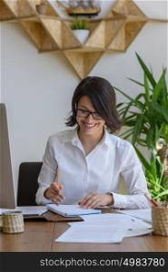 Woman writing at office during working day