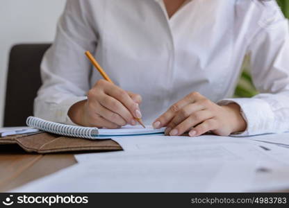 Woman writing at office during working day