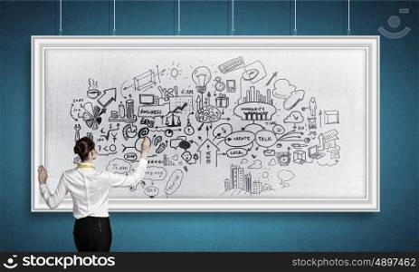 Woman writing on billboard. Rear view of businesswoman drawing business plan on white banner