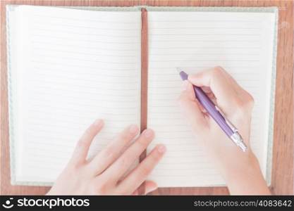 Woman writing on her notebook, stock photo