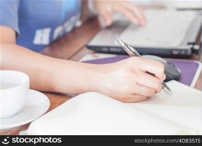 Woman writing on notebook, stock photo