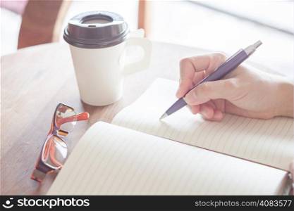 Woman writing on notebook, stock photo