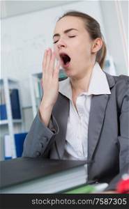 Woman yawning at office desk