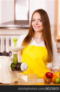 Woman young housewife in kitchen with fruits and juicer preparing to make fresh juice. Healthy eating, cooking, vegetarian food, dieting and people concept