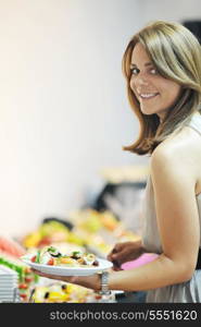 womanl chooses tasty meal in buffet at hotel banquet party restaurant