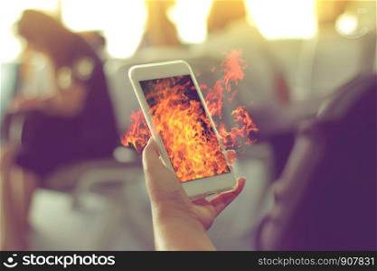 WomanOs hand Using a Smart Phone with flame fire as hot, hot news concept, hot gossip news.