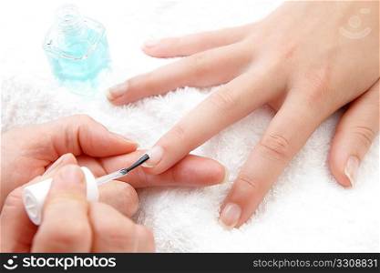 womans finger nails having clear varnish applied on white towel