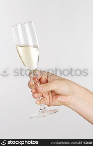 Womans hand holding a glass of white wine