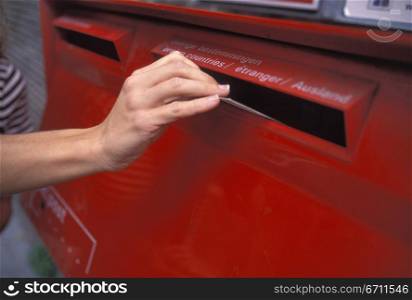 Womans hand posting a letter