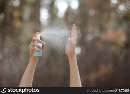 Womans hand pressing Alcohol Spray in the nature for clean her hand. Alcohol Spray is very important in daily life. mosquito repellent or antiseptic.. Womans hand pressing Alcohol Spray in the nature for clean her hand. Alcohol Spray is very important in daily life. mosquito repellent or antiseptic