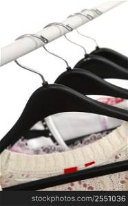 Women&acute;s clothing on a rack on black hangers