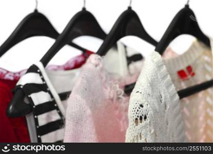 Women&acute;s clothing on a rack, white background