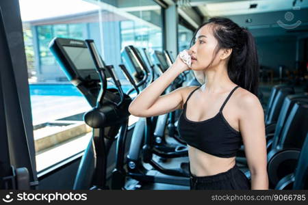 Women after exercising, wipe the face with a white cloth in the gym.